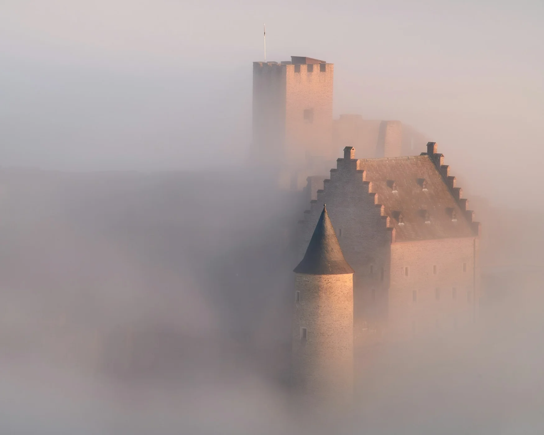 Bourscheid Castle towers in morning mist